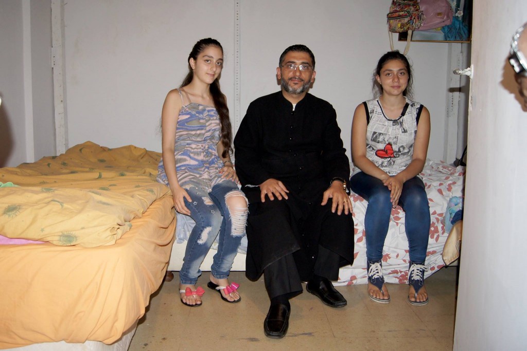 Pfarrer Jack Nasser - Syrisch-Orthodoxer Priester aus Beirut, Zwillingstöchter (beide 15J.) aus Aleppo/Syrien in ihrer Notunterkunft in Beyrut/Libanon